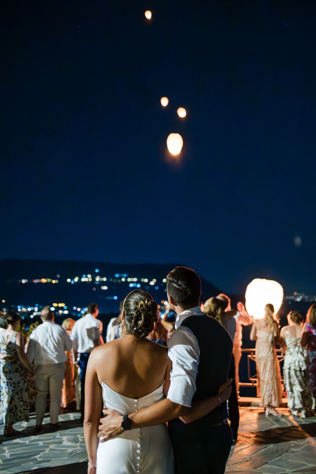 The couple at night with lights over the bay