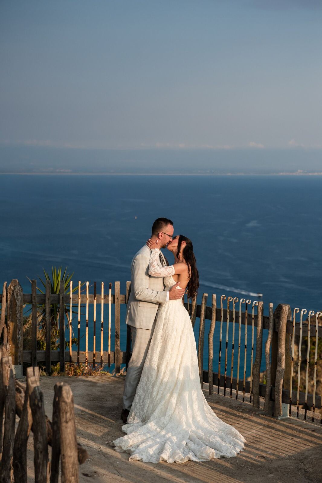 A couple embracing at the cliff edge above the sea