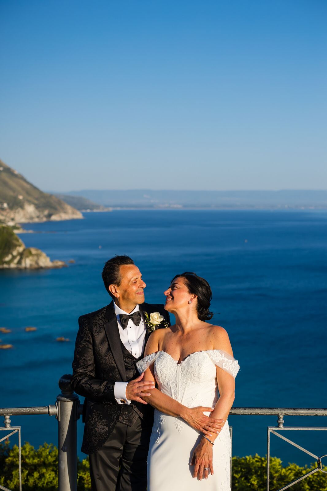 The couple on the terrace with the deep blue sea behind